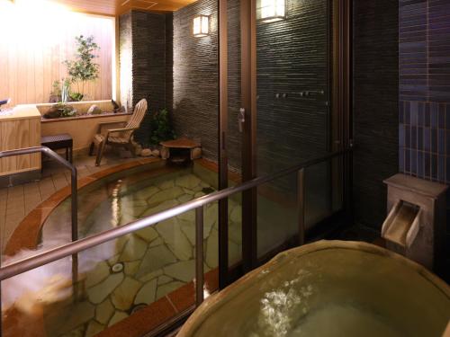 a bath room with a tub in a bathroom at Dormy Inn Sapporo Annex in Sapporo
