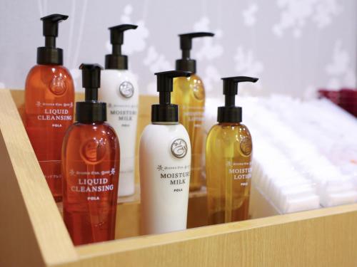 a shelf with four bottles of liquid cleansers on it at Dormy Inn Sapporo Annex in Sapporo