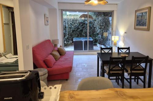 un salon avec un canapé rouge et une table dans l'établissement Apartment with terrace in the city center, à Saint-Tropez