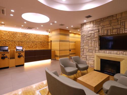 a waiting room with a fireplace and a tv at Dormy Inn Sapporo Annex in Sapporo