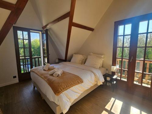 une chambre avec un lit avec deux animaux en peluche dessus dans l'établissement Somptueuse Villa à 5 minutes de Deauville, 18 couchages, piscine, billard, salle de jeux, à Bonneville-sur-Touques