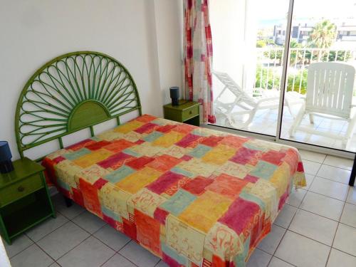 une chambre avec un lit avec une couette colorée dans l'établissement Appartement Natura Beach 3 chambres NB303 - 8 personnes, au Cap d'Agde
