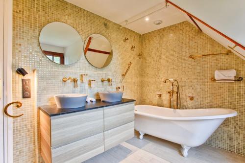 une salle de bain avec une baignoire et un lavabo dans l'établissement Somptueuse Villa à 5 minutes de Deauville, 18 couchages, piscine, billard, salle de jeux, à Bonneville-sur-Touques