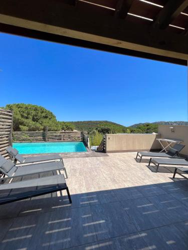 un patio avec deux chaises et une piscine dans l'établissement Villa Ghjulia, à Porto-Vecchio
