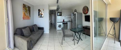 un salon avec un canapé et une table dans l'établissement Appartement Natura Beach - NB304 - 4 personnes, au Cap d'Agde