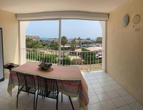 une salle à manger avec une table et une grande fenêtre dans l'établissement Appartement Natura Beach - NB304 - 4 personnes, au Cap d'Agde