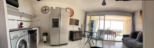 une cuisine avec lave-linge et un salon dans l'établissement Appartement Natura Beach - NB304 - 4 personnes, au Cap d'Agde