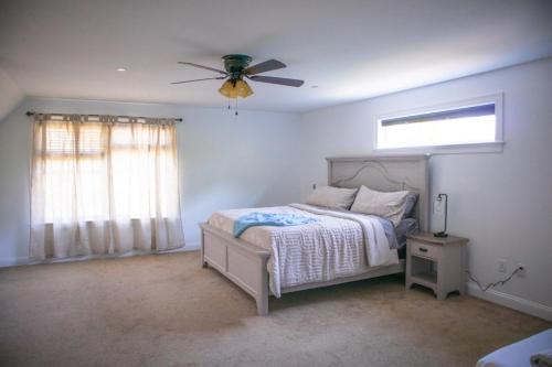 a bedroom with a bed and a ceiling fan at The Cityside Maple House in Falmouth