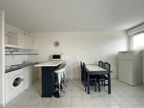 une cuisine avec une table, un évier et une cuisinière dans l'établissement Appartement Natura Beach NB112 - 4 personnes, au Cap d'Agde