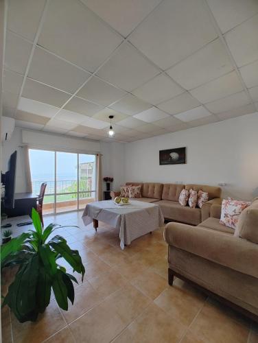 ein Wohnzimmer mit Couch und Tisch in der Unterkunft Large Vacation Apartment With A Stunning View In Isfiya, Mount Carmel - דירת נופש עם נוף מדהים בעספיא in ‘Isfiyā