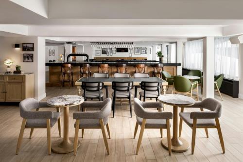 a room with tables and chairs and a kitchen at Mont Gabriel, Sainte-Adèle, a Tribute Portfolio Resort in Sainte-Adèle