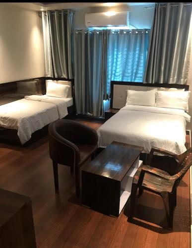 a hotel room with two beds and a chair at Hotel Rica Inn in Namāi