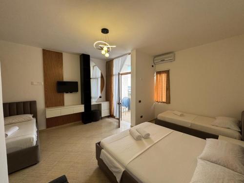 a hotel room with two beds and a television at Eden Hotel in Shëngjin