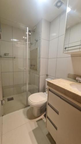 a white bathroom with a toilet and a shower at Vista Park Sul in Brasília