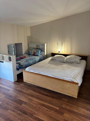 une chambre avec deux lits et un parquet dans l'établissement Grand appartement pour 4 à 7 personnes maximum, à Chef-Boutonne