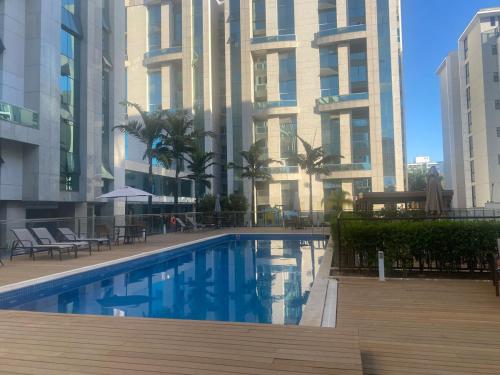 ein Schwimmbad vor einem hohen Gebäude in der Unterkunft Vista Park Sul in Brasilia