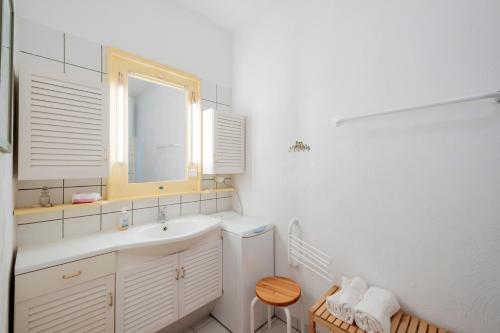 Un baño blanco con lavabo y espejo. en Bel appartement vue mer pour 4, en Soulac-sur-Mer