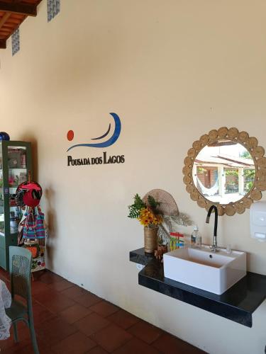 a bathroom with a sink and a mirror on the wall at POUSADA DOS LAGOS in Paulino Neves