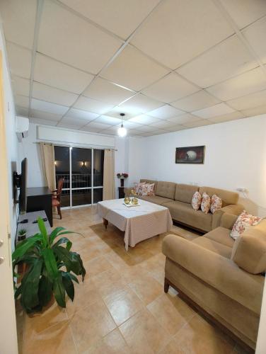 a living room with a couch and a table at Large Vacation Apartment With A Stunning View In Isfiya, Mount Carmel - דירת נופש עם נוף מדהים בעספיא in ‘Isfiyā