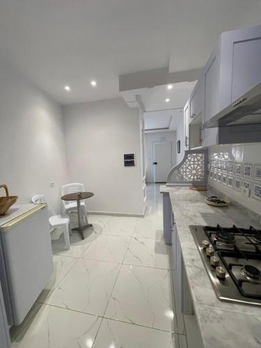 a large white kitchen with a stove top oven at The Blue & White Perle 2 in Sidi Bou Saïd