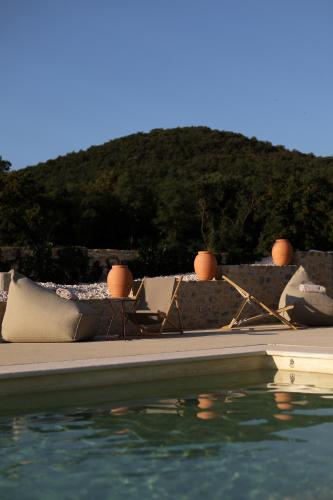 a swimming pool with a table and chairs next to the water at Garenne in Livron-sur-Drôme