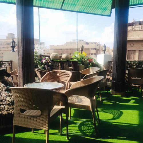 a group of chairs and tables on a balcony at Cecilia Hostel in Cairo