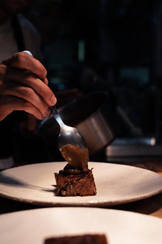 a person eating a piece of chocolate cake on a plate at Garenne in Livron-sur-Drôme