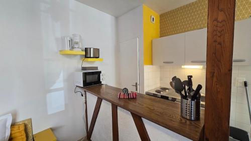 a kitchen with a wooden counter with a microwave at Charme de Loire in Blois