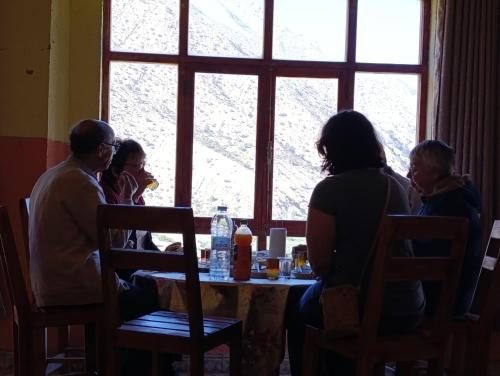 a group of people sitting at a table looking out a window at KASBAH Atlas-Aberdouz in Aït Hattab