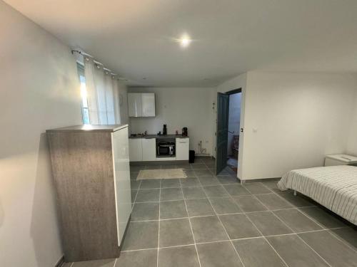 une chambre avec une cuisine et une chambre avec un lit dans l'établissement Studio meublé confort Béziers, à Béziers