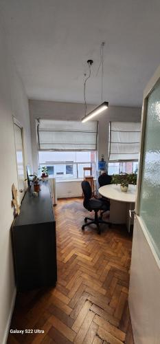 an office with a desk and a table in a room at Hospedaje reconquista in La Porteña