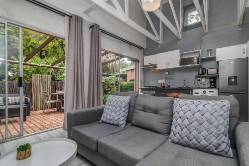 a living room with a couch and a kitchen at Sitatunga Guest Lodge in Johannesburg