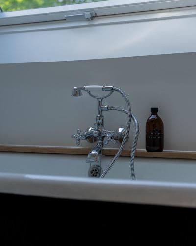 a shower nozzle sitting on a window sill with a bottle at Fleur de Pivoine in Sint-Martens-Latem