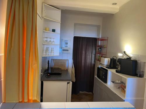 Cette chambre dispose d'une cuisine avec un bureau et un four micro-ondes. dans l'établissement Studio vue mer proche port, à Sanary-sur-Mer