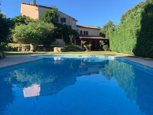 a blue swimming pool in front of a house at Spacious Villa with Pool and Fireplace in Roquebrune-sur-Argens