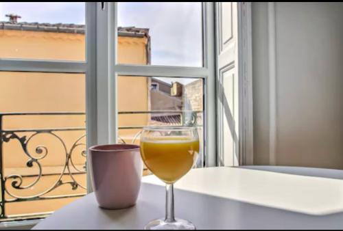 un verre de vin assis sur une table devant une fenêtre dans l'établissement Le Méridien-Studio Cosy en plein centre, à Nîmes