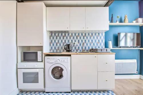 une cuisine avec des armoires blanches et une laveuse et une sécheuse dans l'établissement Le Méridien-Studio Cosy en plein centre, à Nîmes