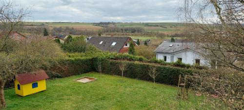 an aerial view of a yard with a yellow house at Ferienwohnung Ragwurz in Blieskastel