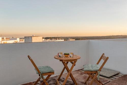 a small table and two chairs on a balcony at Casa Susan, Penthouse apartment, view over Old Town & the Sea in Vejer de la Frontera