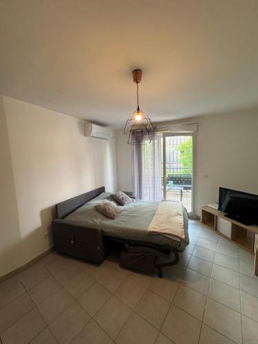 une chambre avec un lit et une grande fenêtre dans l'établissement Appartement T2 proche des calanques Sormiou et Morgiou, à Marseille