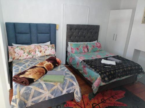 two beds sitting next to each other in a room at 37 Grant prix lodge in Cape Town