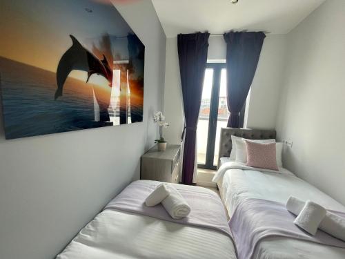 two beds in a room with a dolphin painting on the wall at OneLuxStay near Antwerp Central in Antwerp