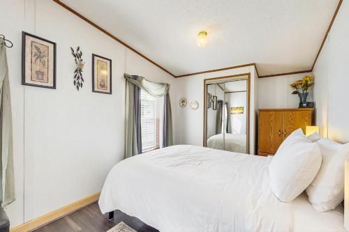 a bedroom with a white bed and a mirror at Assateague Point Vacation in Berlin