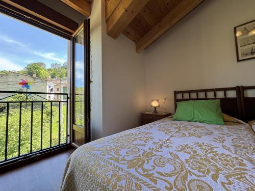 ein Schlafzimmer mit einem Bett und einem großen Fenster in der Unterkunft Casa Marisa en Cangas de Onís VV-2929-AS in Cangas de Onís