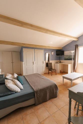 une chambre avec un lit et un salon dans l'établissement Mas Saint-Ange, à Lunel