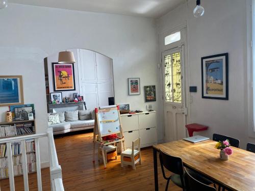 un salon avec une table et un canapé dans l'établissement VILLA GUILHEMERY LES ANNÉES 30 - Le jardin enchanté, à Toulouse