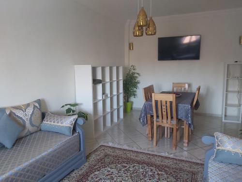 a living room with a couch and a table at Cute affordable apartment in Marrakech