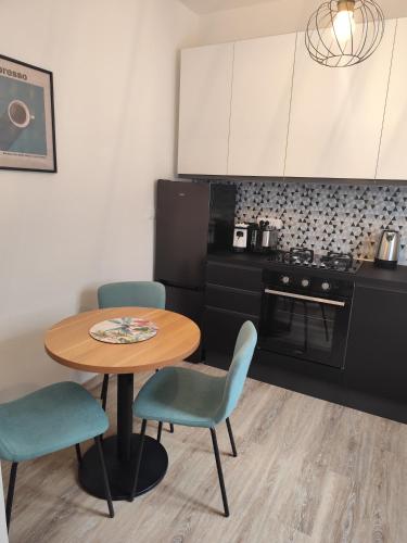 a kitchen with a table and two chairs and a table and a kitchen at Appartamento in centro by La Dolce Riva in Lugo