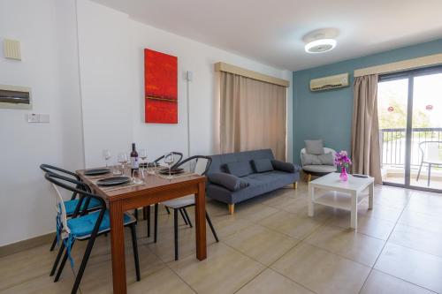 a living room with a table and a couch at Pernera One Suites in Pernera Protaras in Paralimni