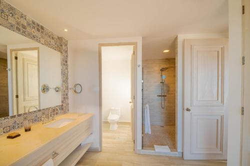a bathroom with a large mirror and a sink at Mar del Cabo By Velas Resorts Adults Only in San José del Cabo